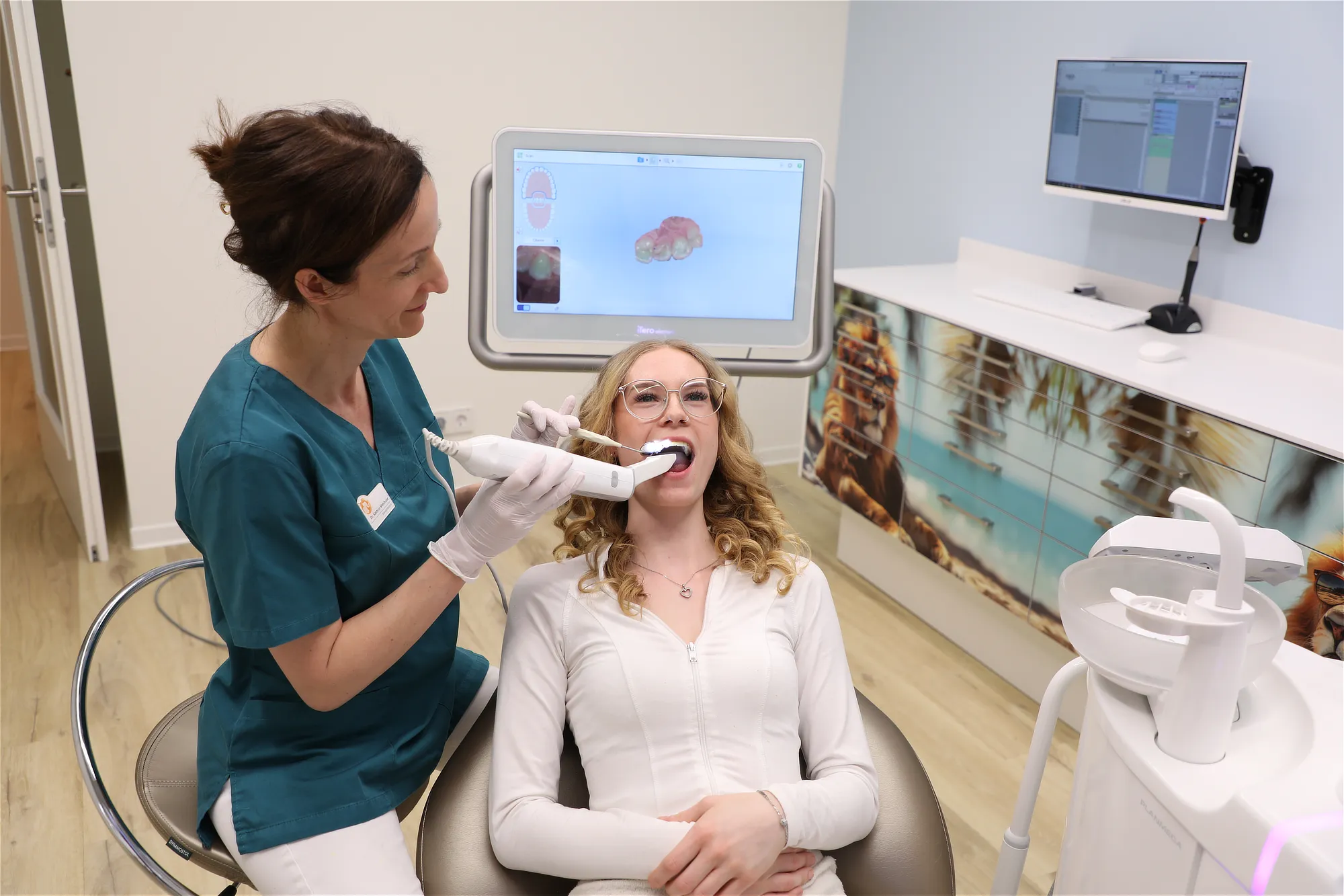 Zahnärztin scannt Zähne einer Patientin mit digitalem Intraoral-Scanner